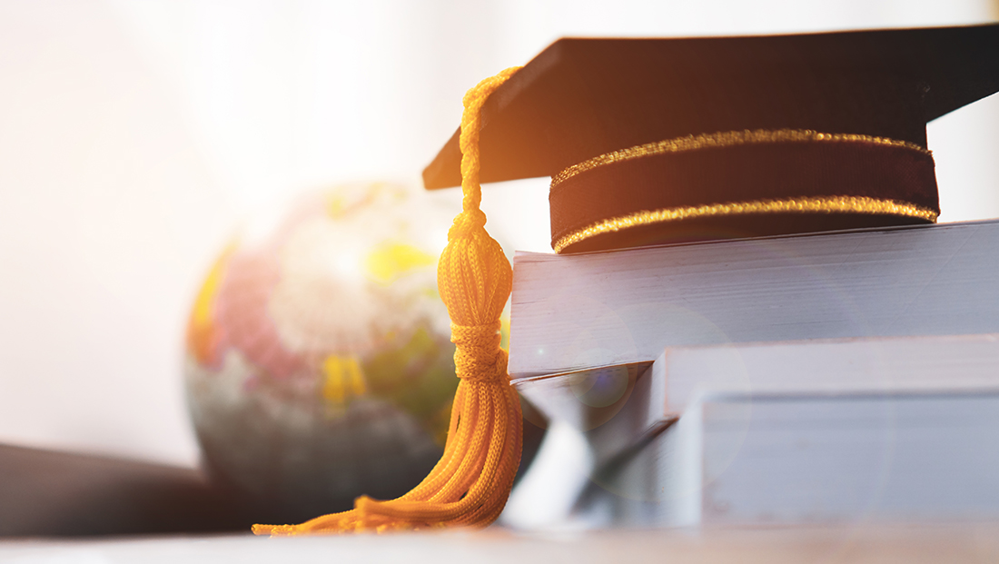Recruiting international graduates: graduation cap in front of a globe