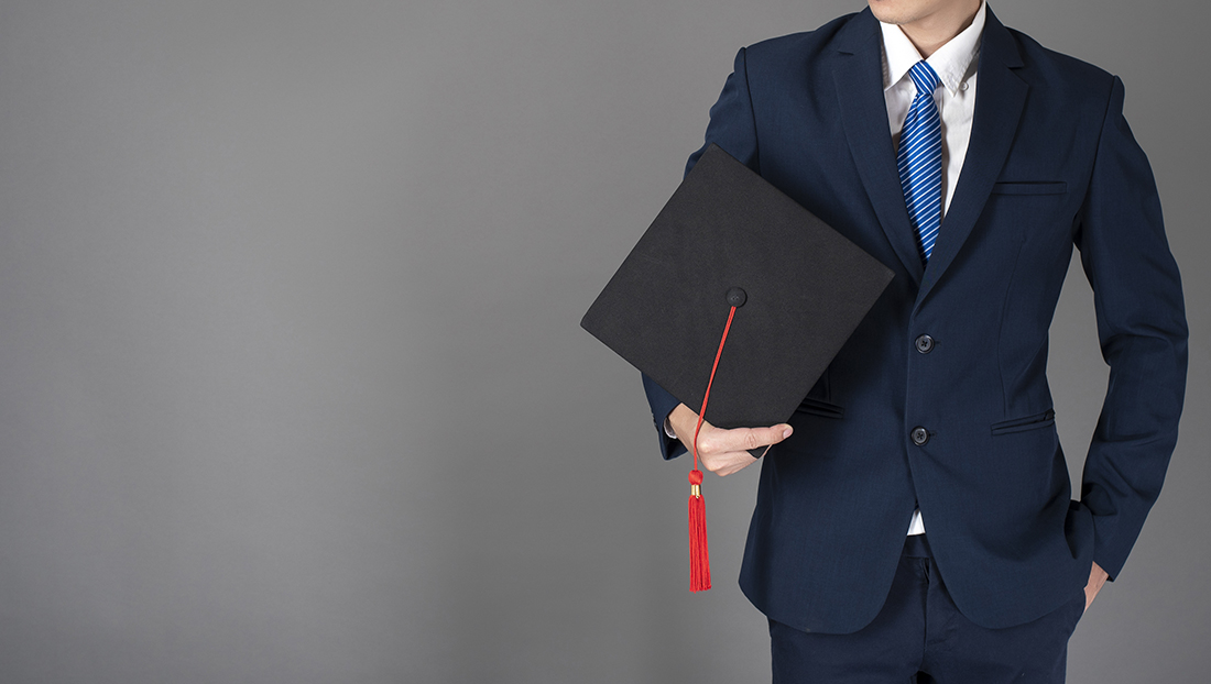 advertise graduate roles: young professional holding a graduation hat