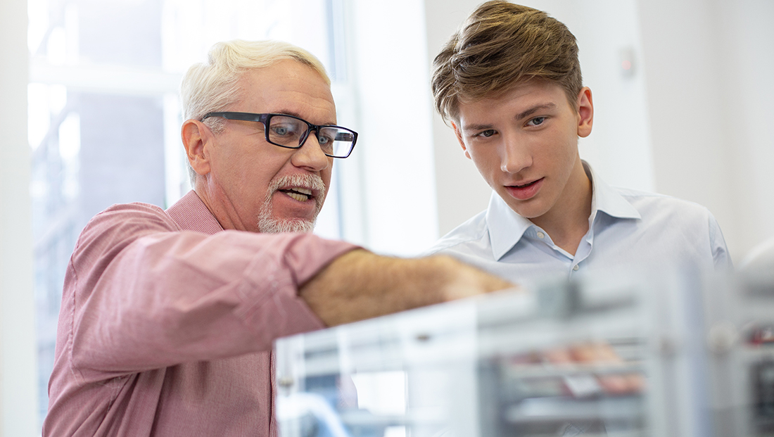 IBM internships: senior engineer explaining the 3D printer mechanism to a young intern