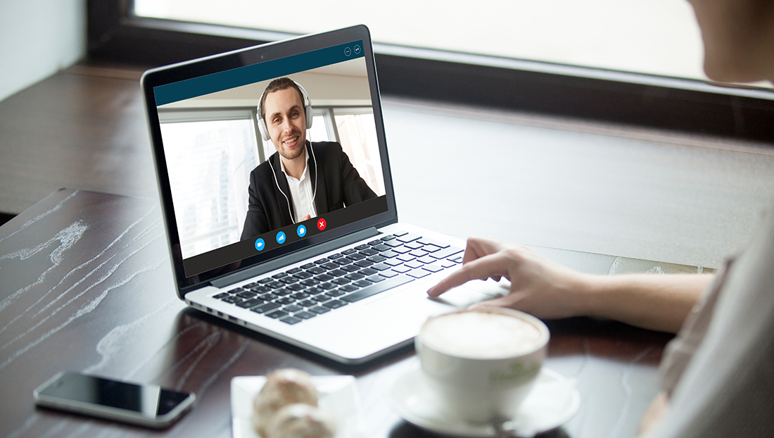 Online recruitment: a woman talking to a man in headphones via video call