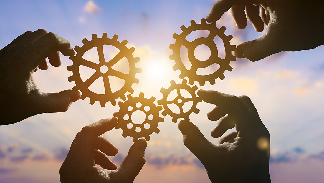 Strengths-based recruitment: four hands connecting gears