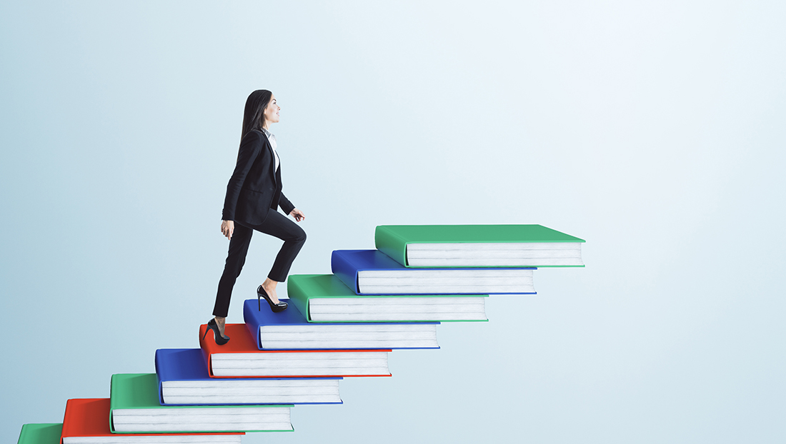 Social mobility in graduate recruitment: a businesswoman going up a book pile ladder