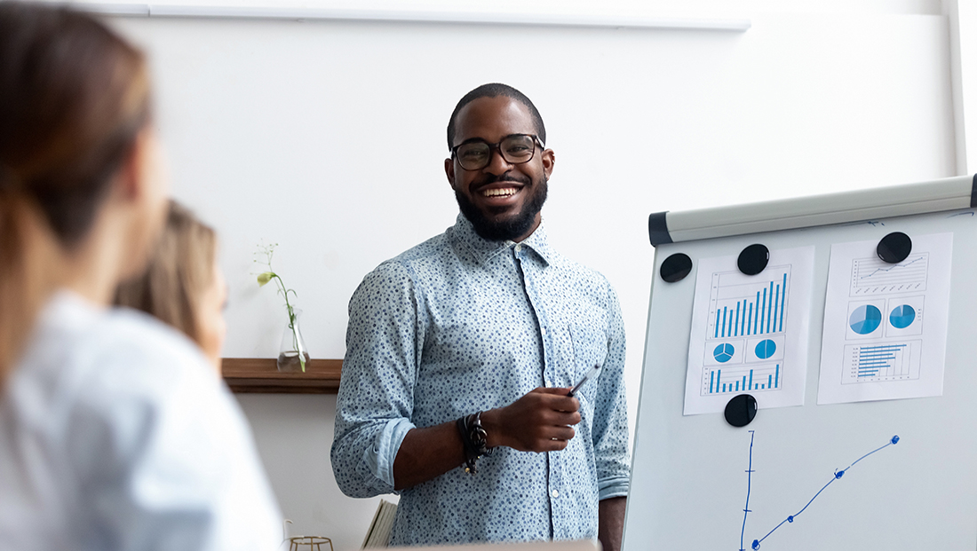 Diversity on Board: Black manager presents report standing near whiteboard