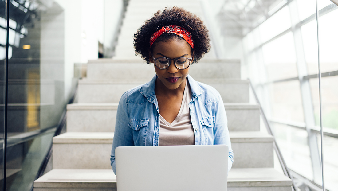Supporting Black students: Black female university student working on a laptop