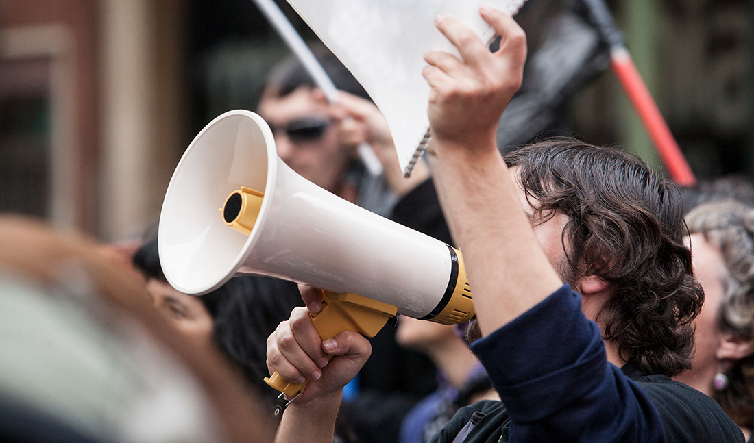 marking boycott: a protester talking into megaphone and holding a sign