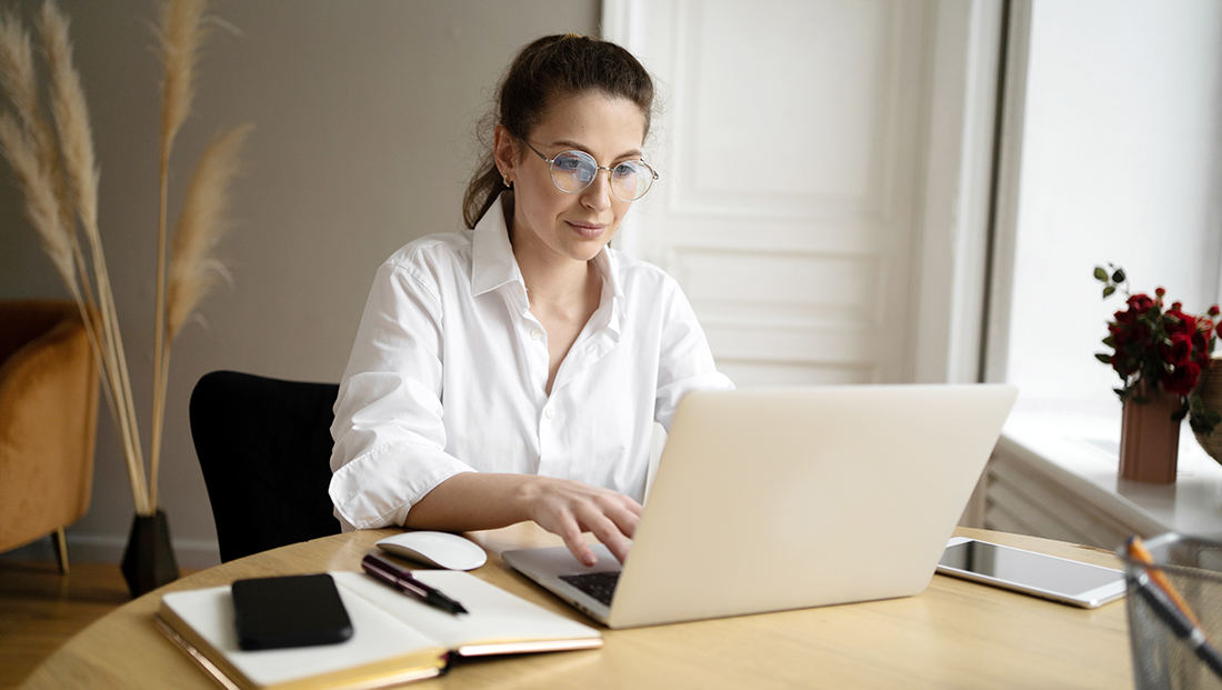 Hybrid work experience: a woman with glasses working from home