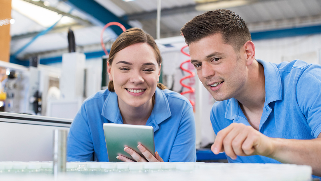 recruiting school and college leavers: engineer and apprentice with a digital tablet working in a factory