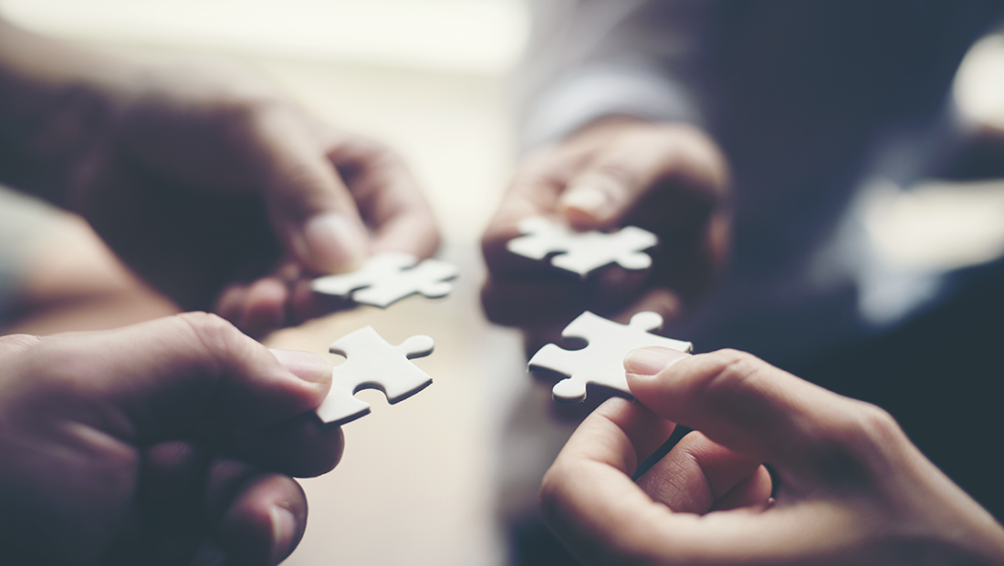 university and employer relationships: hands holding jigsaw puzzles
